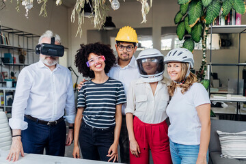 Smiling business colleagues wearing different glasses and helmets in office