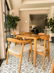 Natural light illuminates a cozy cafe interior with wooden furniture and patterned tiles