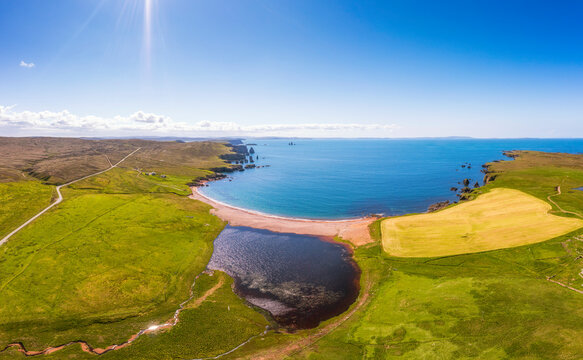UK, Scotland, Aerial view of Saint Magnus Bay in summer with Drongs sea stacks in background