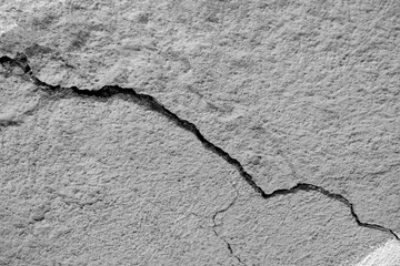 Big winding descending crack on old plastering wall. Copy space. Black and white photo. Selective...