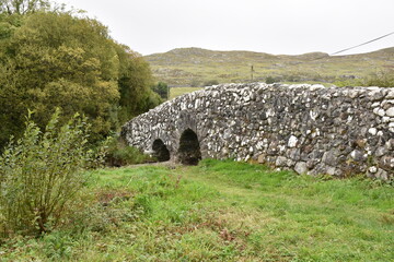 Historic stone bridge over a stream near Tongue village, Sutherland, Highlands of Scotland. Typical...
