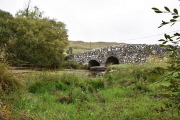 Historic stone bridge over a stream near Tongue village, Sutherland, Highlands of Scotland. Typical...