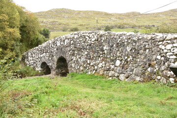 Historic stone bridge over a stream near Tongue village, Sutherland, Highlands of Scotland. Typical...