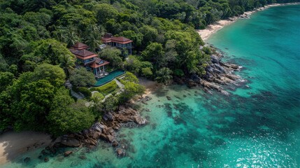 Aerial view of a private beachfront villa surrounded by lush greenery.