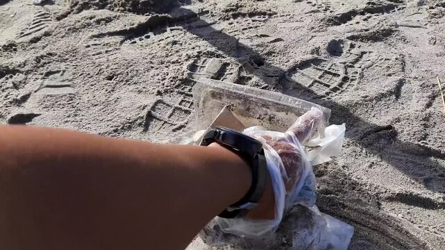 Man Hand Picking Up Plastic Waste on Beach in Pariaman, Indonesia