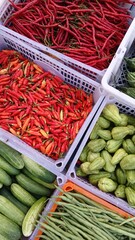 Various kinds of colorful fresh vegetables in plastic boxes sell at traditional market.