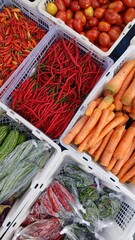 Various kinds of colorful fresh vegetables in plastic boxes sell at traditional market.