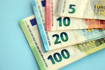 Big amount of european euro currency money notes on blue color table close up
