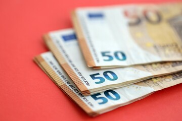 Big amount of european euro currency money notes on red color table close up