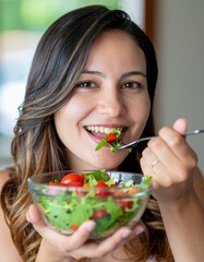 Close-up of a woman enjoying a colorful salad, with focus on her smiling mouth and forkful of fresh vegetables. A vibrant and healthy eating concept perfect for lifestyle, wellness, or nutrition theme