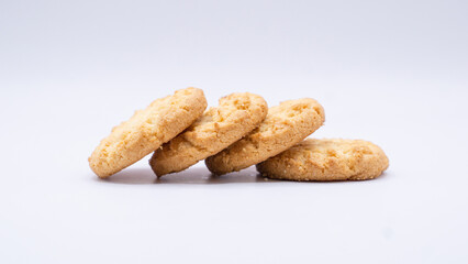 Four Golden Cookies Leaning on a White Surface