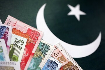 Pakistan rupees banknotes on Pakistani flag background. The current Pakistan money bills