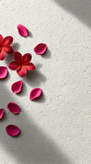 Vibrant pink flower petals scattered on a textured light background, creating a serene atmosphere, perfect for decorative or artistic purposes with copy space