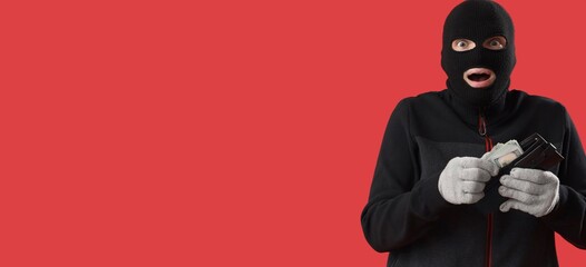 Shocked male burglar with wallet of money on red background with space for text