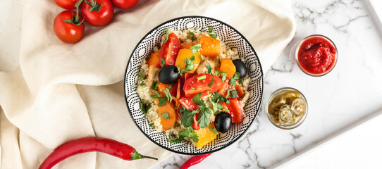 Bowl with couscous and vegetables on light background