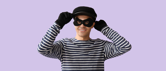 Male thief on lilac background