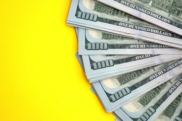 Big amount of United States hundred dollar bills on yellow background