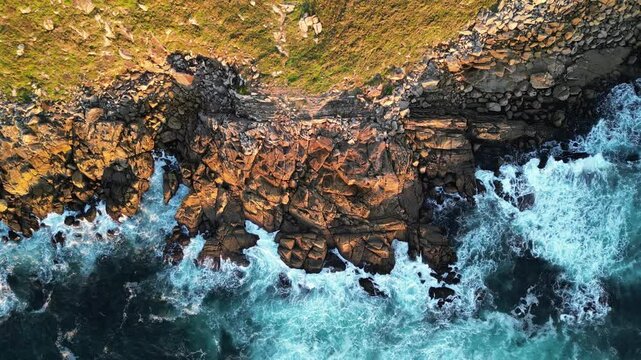 Aerial view of rocky coast and crashing waves, Spain.