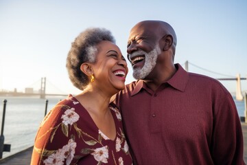 Senior african american couple laughing and enjoying time together by the bay