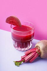 Glass of healthy beet juice on colorful background