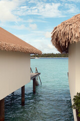 A luxury overwater villa in the Maldives with turquoise ocean and clear sky.  Close-up of water...