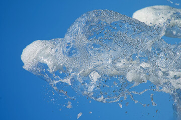 Captivating image of water splashes against a brilliant blue sky, embodying freshness and cooling...