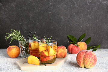 Board with glasses of fresh peach lemonade and rosemary on white table