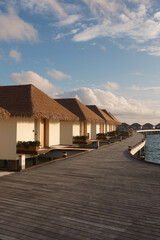 A luxury overwater villa in the Maldives with turquoise ocean and clear sky. Dream destination island