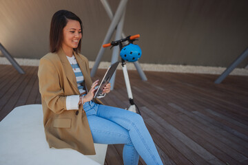Asian woman with e scooter in town near business quart