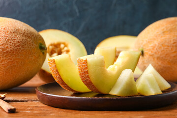 Plate with pieces of sweet melon on wooden table