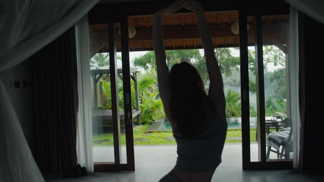 beautiful red-haire gitl doing stretching in the morning witho green jungle background on Bali