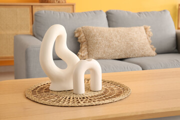 Wooden coffee table with decor in interior of living room, closeup