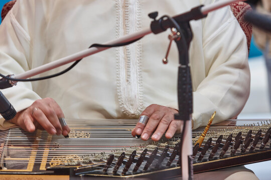 Traditional folk moroccan musician with wooden string instrument. Qanun