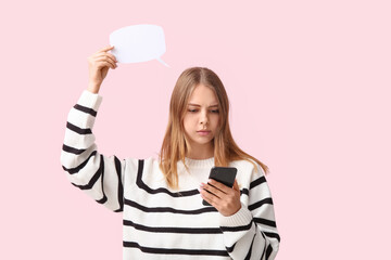 Pretty young woman with blank speech bubble and mobile phone on pink background