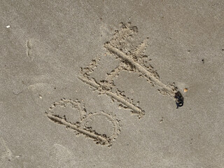 A childs hand has written BFF (best friends forever) in the sand on the beach of the North Sea coast