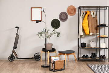 Interior of stylish hall with electric scooter and coat rack