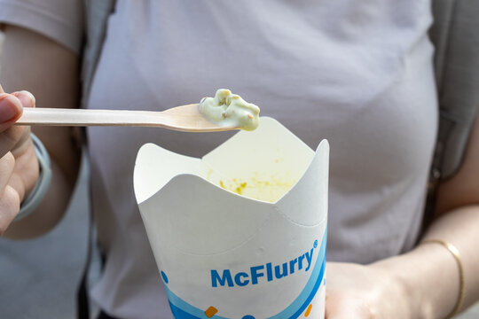 Poznan, Poland - June 18, 2025: McFlurry ice cream in a branded cup held by a person with a wooden spoon, enjoying a popular fast food dessert