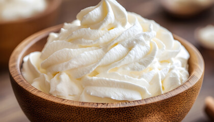 Fototapeta premium A close-up shot of whipped cream in a wooden bowl, perfect for desserts