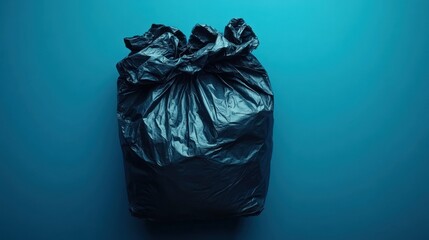 Dramatic Studio Shot of a Black Garbage Bag Isolated on Blue Background