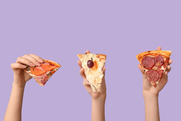 Many hands holding pizza slices on lilac background