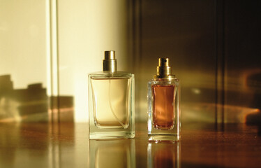 two perfume bottles on a dresser, seen in a beautiful soft sunlight