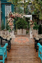 Rustic outdoor wedding arch with floral arrangements and wooden seating