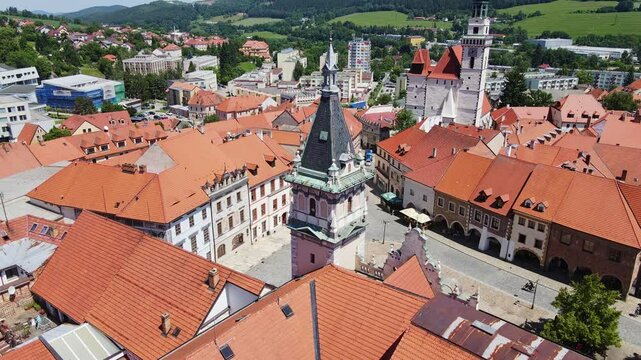 Czech old town with red roofs and towers shown in tranquil static drone capture