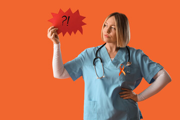 Beautiful mature female doctor with ribbon and speech bubble on orange background. Multiple...