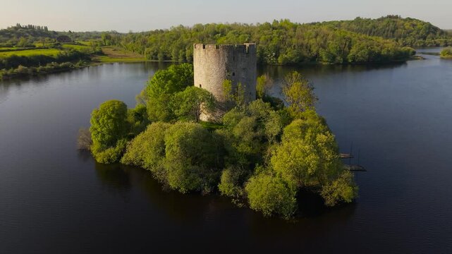Cloughoughter Castle, a ruined circular fortress, sits on a small island in Lough Oughter, surrounded by lush greenery in County Cavan, Ireland
