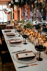 Elegant wedding reception table setting with candles and black goblets