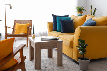 Interior of stylish living room with yellow sofa and armchairs