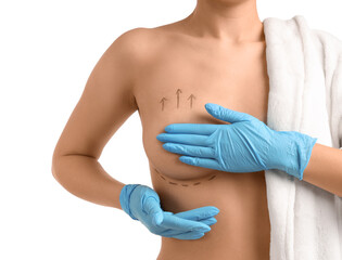 Naked young woman in medical gloves with marks on her breast against white background, closeup....