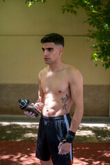 Young athlete hydrating after calisthenics workout outdoors
