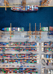 Aerial top down view of a large container cargo ship terminal with industrial vessels being loaded...